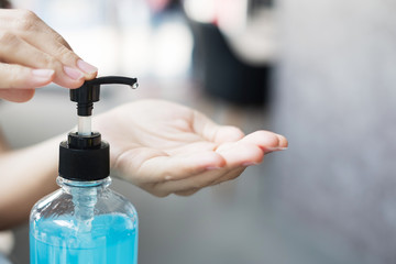 Woman hands using wash hand sanitizer gel dispenser, against Novel coronavirus or Corona Virus...