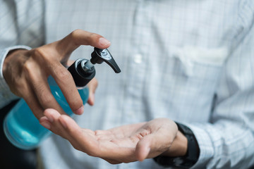 man hands using wash hand sanitizer gel dispenser, against Novel coronavirus or Corona Virus Disease (Covid-19) at public train station. Antiseptic, Hygiene and Healthcare concept