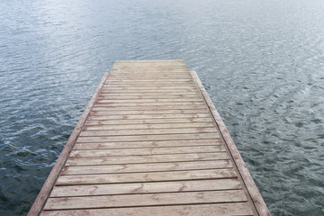Fototapeta premium Wooden bridge for swimming on the shore of a lake. Blue water, summer nature landscape. Environmental concept, Latvia, Europe.