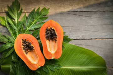 Papaya slices in a dish on wooden background.