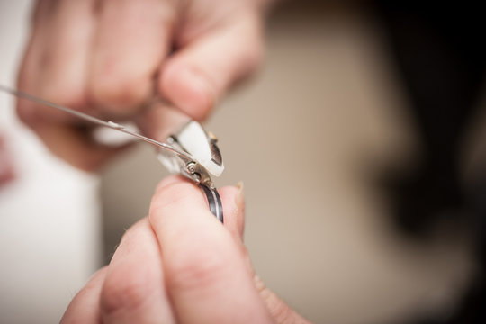 Ein Optiker justiert einen B&uuml;gel einer Brille mit einer Zange