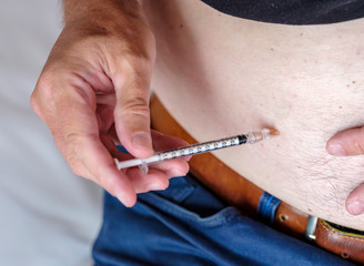 Person using a syringe to get an injection