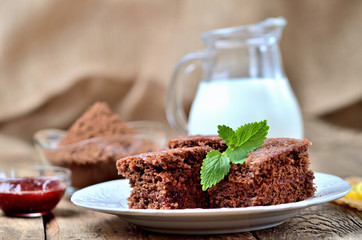 Gingerbread cakes with leaves of mint and raspberry jam. Jug of milk in background.