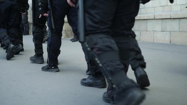 Armed police officer. Special force with armored uniform at city street. Law and order. Opposition rallies, detentions and arrests