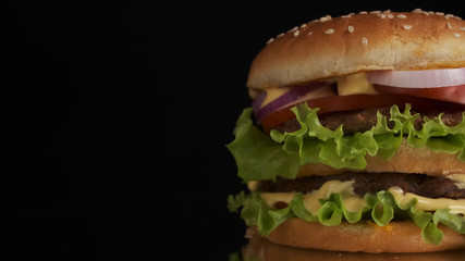 Appetizing burger on a black background. Close-up. copy space