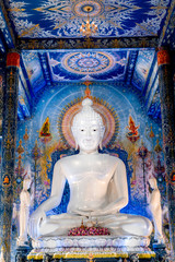 Main buddha statue located in the Blue Temple, the most iconic temple in Chiang Rai. A white big buddha statue.