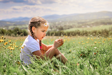 Attractive girl relaxing on the green grass on the top of the mountains in the morning