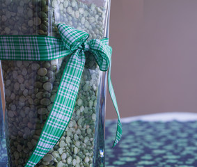 St Patricks Day vase arrangement with green ribbon over shamrock cloth