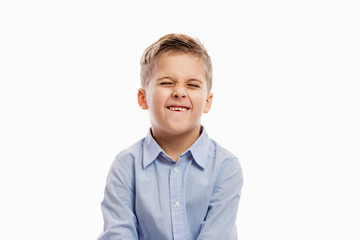 Laughing school boy in a blue shirt. Isolated over white background.