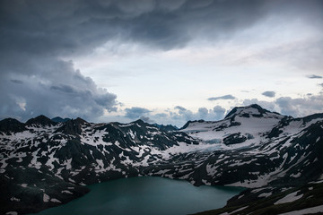 alpine lake with snow during a storm