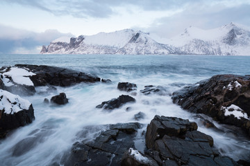 Panorama of snowy fjords and mountain range, Senja, Norway Amazing Norway nature seascape popular tourist attraction. Best famous travel locations. beautiful sunset within the amazing winter landscape