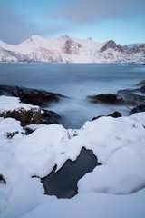 Naklejka na ściany i meble Panorama of snowy fjords and mountain range, Senja, Norway Amazing Norway nature seascape popular tourist attraction. Best famous travel locations. beautiful sunset within the amazing winter landscape