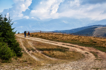 Fototapeta na wymiar Two friends travel in the mountains with backpacks. Beautiful mountain landscape view. Carpathians, Ukraine.