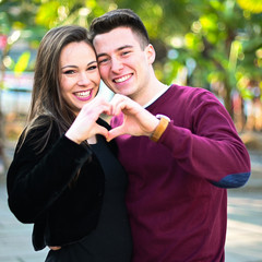 Young couple making a heart shape with their hands