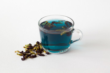 butterflu pea tea. glass cup of blue herbal tea on a white background. Healthy lifestyle. cup of hot blue tea with dry flowers on a white table. Fresh Cold drinks, blue cocktail. copy space.