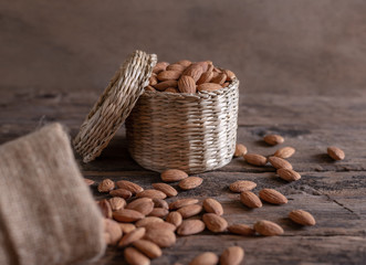 Almond in basket on blurred wooden background