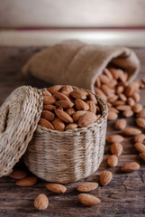 Almond in cloth bag on blurred wooden background