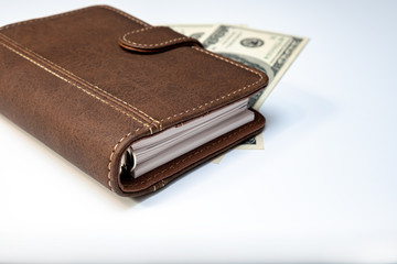Dollars, notebook and a pen on white background close up as a symbol of wealth and financial prosperity, earning money and richness