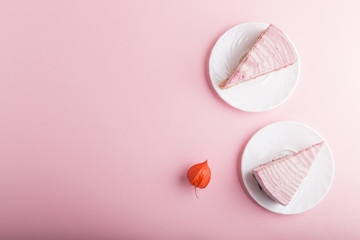 Homemade pink cheesecake on a pink pastel background. top view, copy space.
