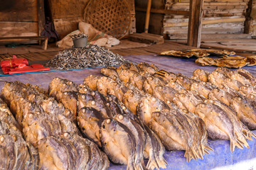 A dried fish, put tightly next to one another on a canvas, drying on the sun and waiting to be sold on a local market in Maumere, Flores, Indonesia. Local speciality.