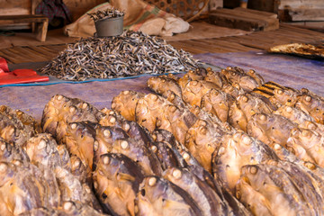 A dried fish, put tightly next to one another on a canvas, drying on the sun and waiting to be sold on a local market in Maumere, Flores, Indonesia. Local speciality.