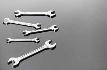 Set of wrenches on a gray background. Mirror surface. View on a plane.Copy space.