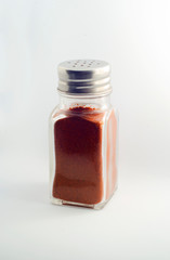 paprika in a spice container on a white background