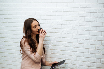 business woman holding tablet and drinking coffee © ostap_davydiak