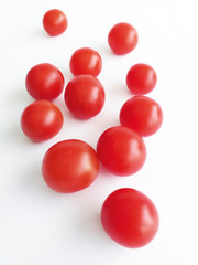Front view of a pile of red cherry tomatoes on white background. Healthy and organic food.