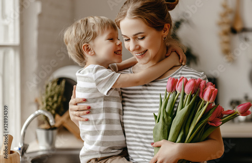 happy mother's day! child son gives flowers for  mother on holiday
