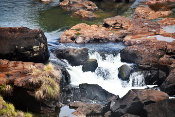 Iguazu roaring waterfalls against a jungle and gray sky