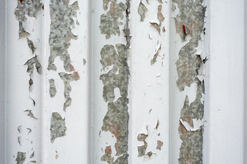 detail of a peeled white painted galvanized metal plate
