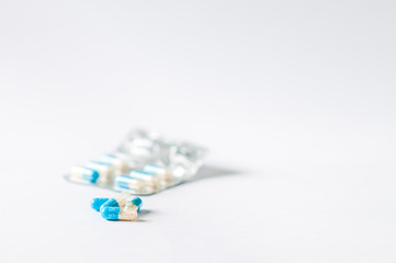 Closeup blue-white antibiotics capsule pills in blister pack. Pharmacy background. Antimicrobial drug resistance. Pharmaceutical industry. Global healthcare.