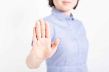 拒否のハンドサインをするワンピースを着た女性