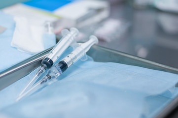 Two syringes with medicine lie in the treatment room, close up