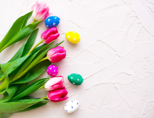 Happy ester. color eggs with tulips on background top view