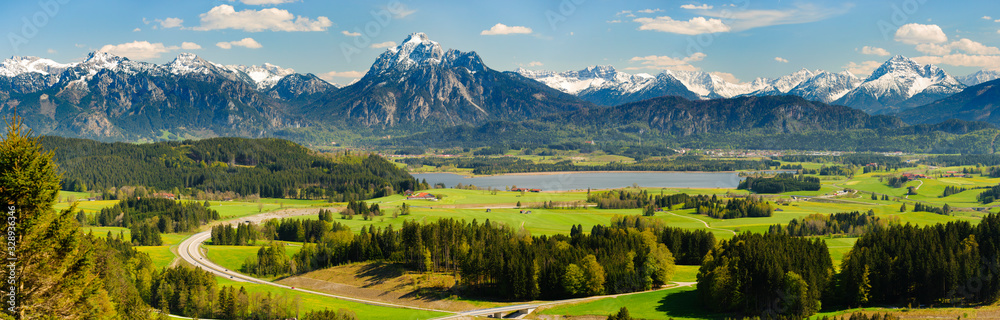 Poster panoramic landscape with meadow and lake in front of alps mountains