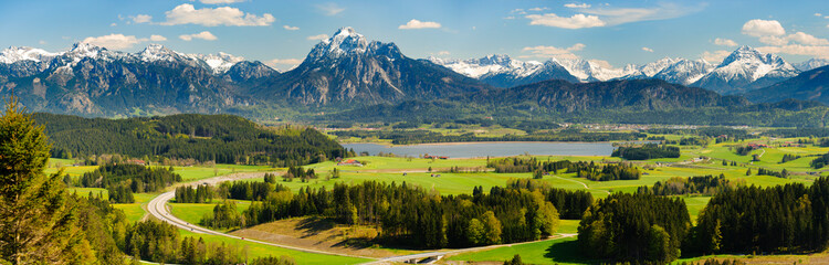 panoramic landscape with meadow and lake in front of alps mountains - obrazy, fototapety, plakaty