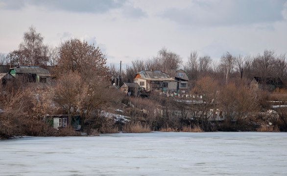 Spring scenery with authentic village on the hill. Snow melting.