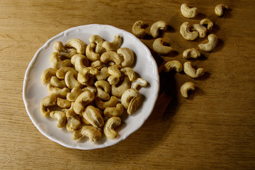 Cashew nuts. The cashew tree is a tropical evergreen tree that produces the cashew seed and the cashew apple.