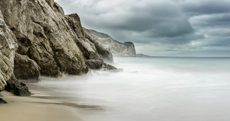Playa de la cala Vallcarca en el parque natural del Garraf con nubes de tormenta (Cataluña, España)
