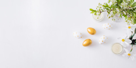 Flat lay easter composition with spring flowers in a vase and easter eggs on a light background