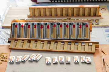 Parts of a disassembled accordion in process of restoration and repair with the set of tabs