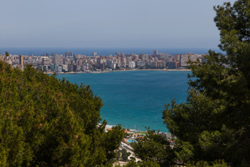 View of Cabo de la Huerta from the Castle of Alicante framed among pine trees