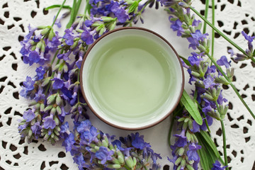Lavender tea in clay cup with lavender flowers on a paper napkin. Top view.