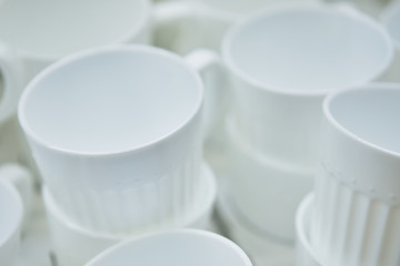 Modern white ceramic mugs standing nearby.