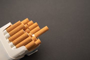 Cigarettes in pack. Yellow filter. Harm to health. Bad habit.