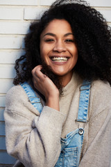  pretty young black woman with afro hair laughing and enjoying