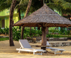 Long Beach, Phu Quoc Island, Vietnam. Nobody on the beach. Palm tree bamboo umbrellas and sun chairs in background.