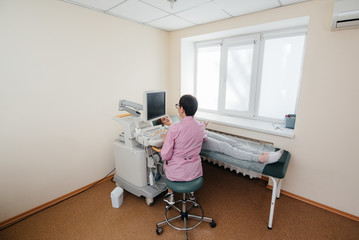 A pregnant girl gets an ultrasound of her abdomen at the clinic. Medical examination